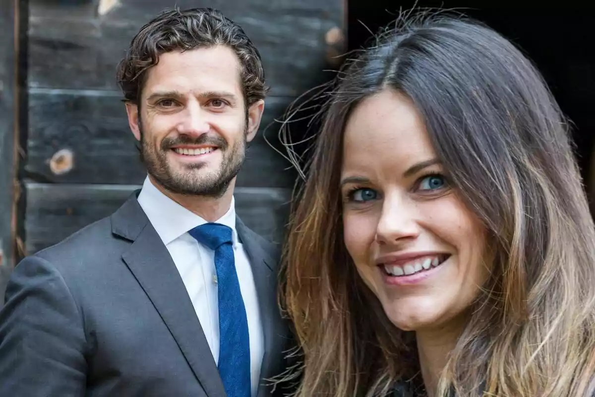 A smiling couple posing in front of a wooden background.
