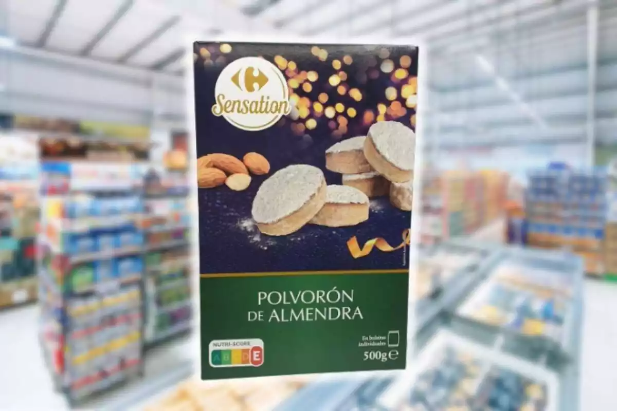 Fotomontaje con un fondo de un supermercado y al frente la caja de 500 g de polvorón de almendra de la marca Sensation de Carrefour