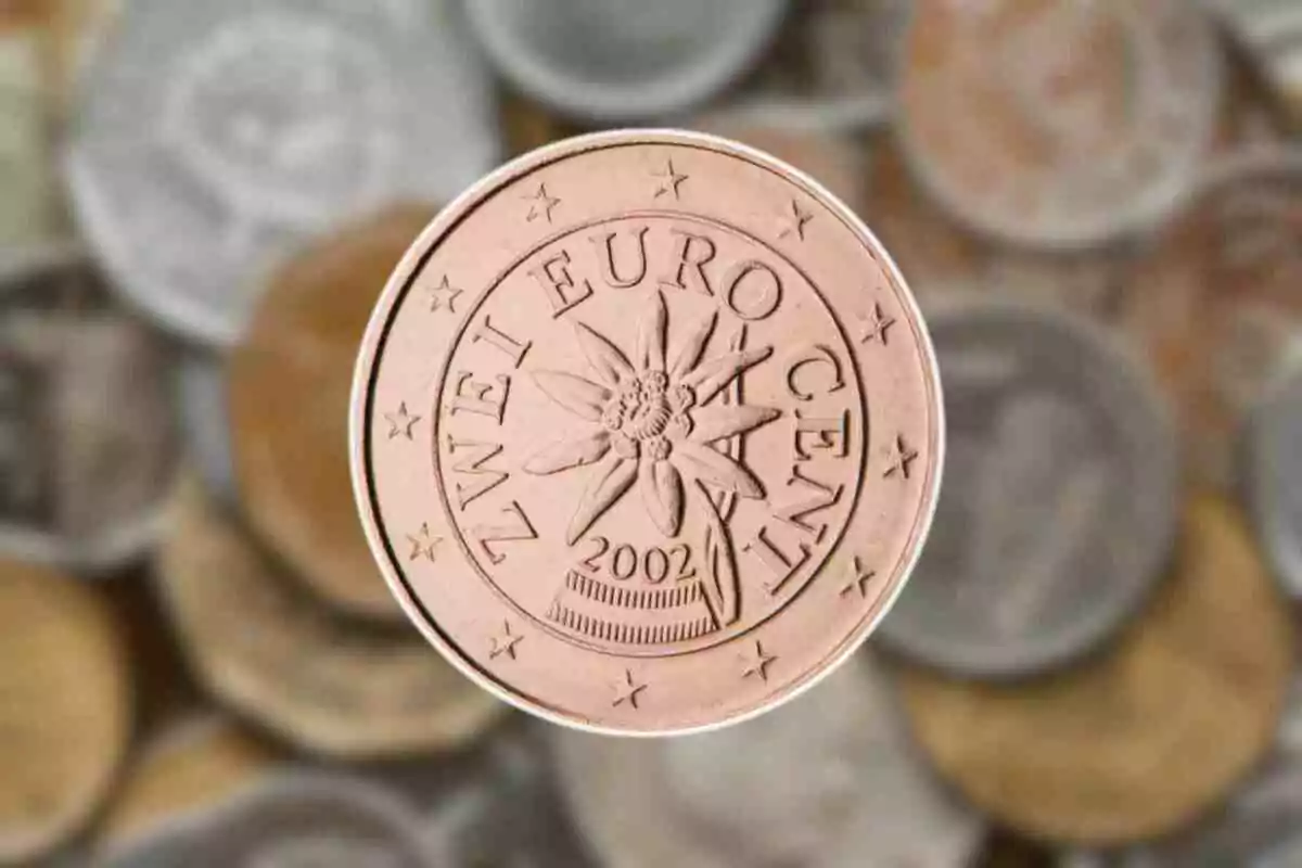 Moneda de dos cèntims dʻeuro amb disseny de flor edelweiss i fons dʻaltres monedes desenfocades. Moneda de dos cèntims dʻeuro amb disseny de flor edelweiss i fons dʻaltres monedes desenfocades.