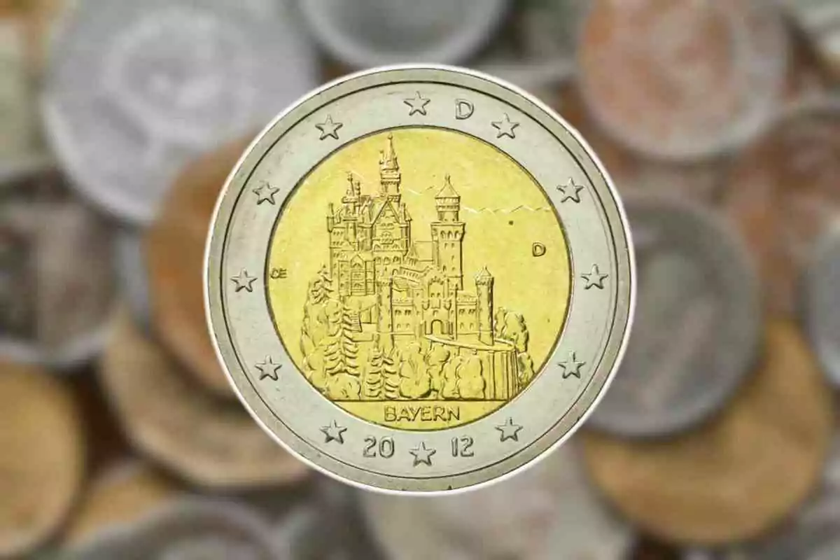 Moneda de dos euros amb disseny del castell de Neuschwanstein al centre i fons d'altres monedes desenfocades. Moneda de dos euros amb disseny del castell de Neuschwanstein al centre i fons d'altres monedes desenfocades.