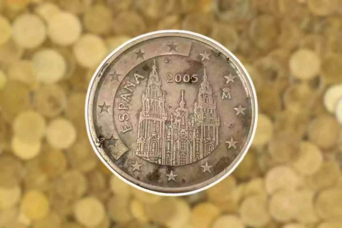 Moneda de 5 cèntims d'Espanya de l'any 2005 amb la Catedral de Santiago de Compostel·la al revers sobre un fons de monedes desenfocades.