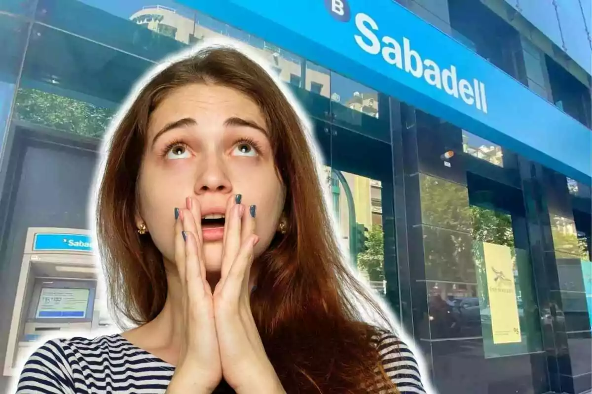 Una dona amb expressió de sorpresa o preocupació davant d'una sucursal del banc Sabadell.