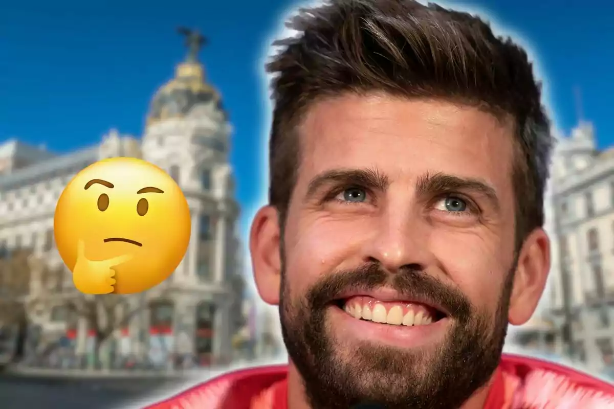 Un hombre sonriente con barba y cabello corto frente a un edificio emblemático con una expresión pensativa representada por un emoji.