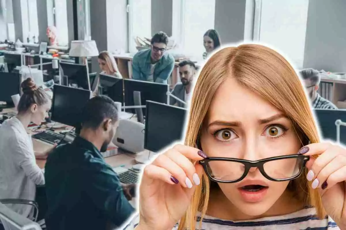Una dona amb expressió de sorpresa sosté les ulleres davant d'una oficina plena de persones treballant en ordinadors.