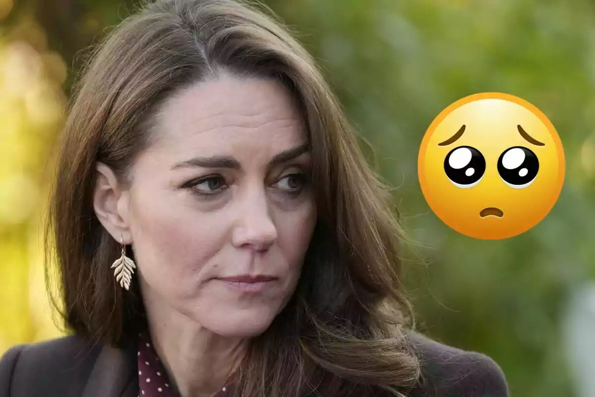 Brown-haired woman with a serious expression and a sad face emoji next to her against a blurred natural background