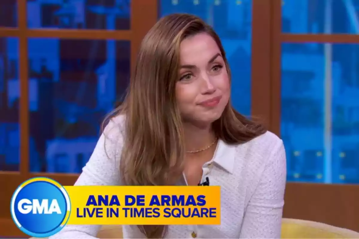 Ana de Armas is sitting on a television set with a blue and yellow background. Capture from 'Good Morning America'. Ana de Armas is sitting on a television set with a blue and yellow background. Capture from 'Good Morning America'.