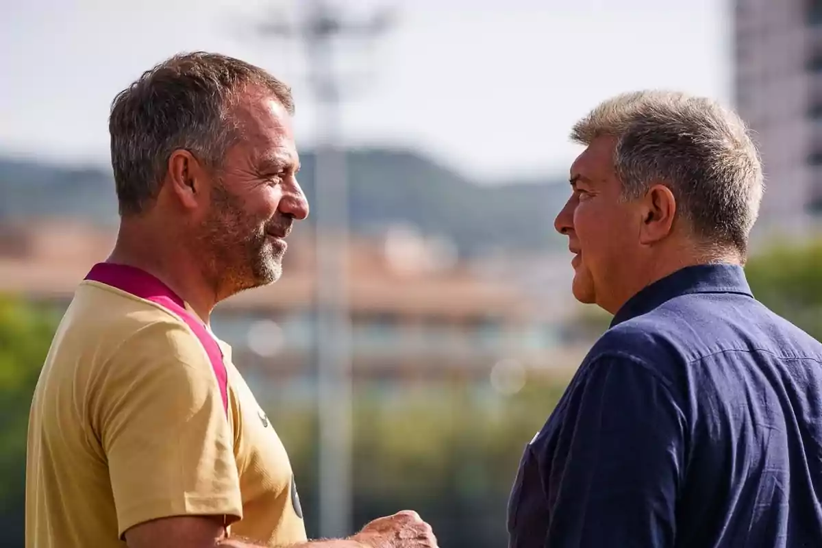 Two men chatting outdoors, one in a yellow t-shirt and the other in a blue shirt. Two men chatting outdoors, one in a yellow t-shirt and the other in a blue shirt.