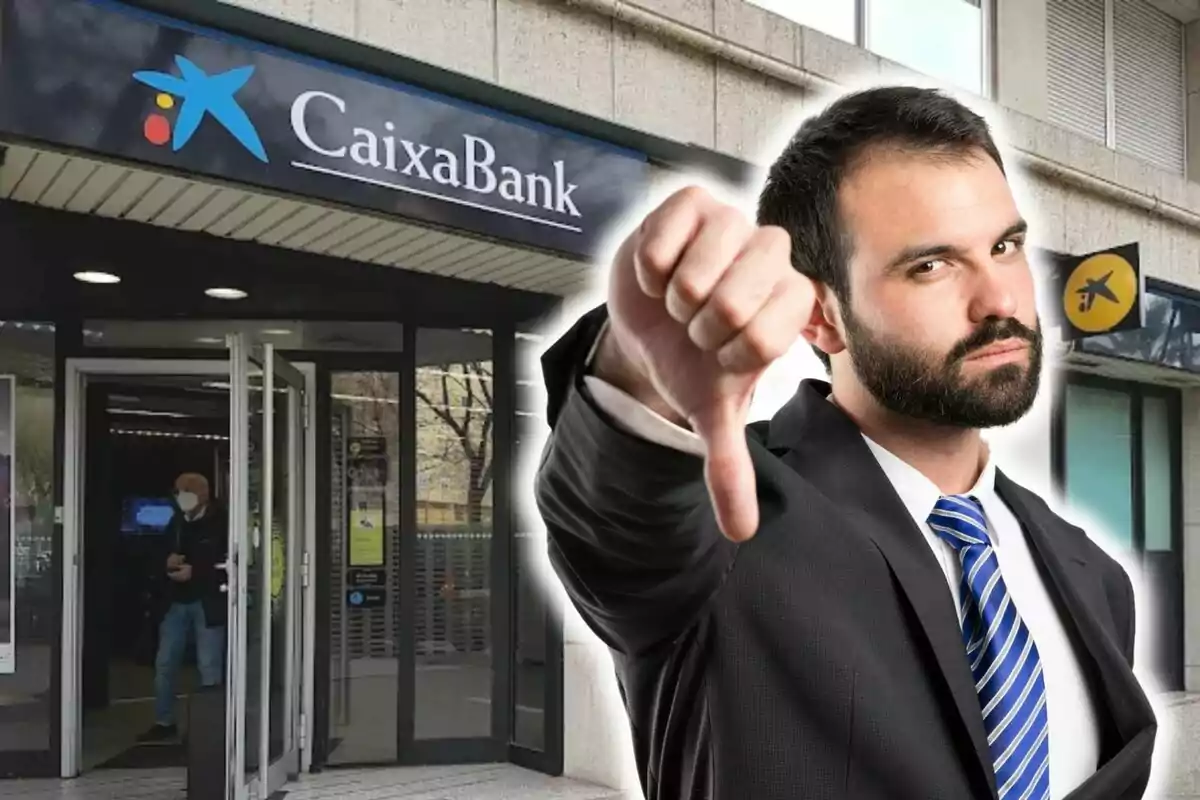 Un home amb vestit i corbata blava fent un gest de desaprovació amb el polze cap avall davant d?una sucursal de CaixaBank.