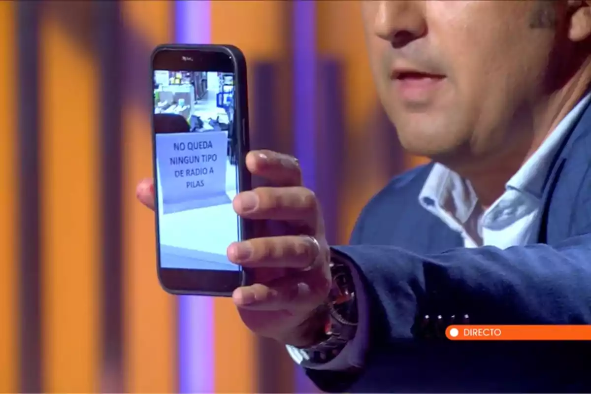 Iker Jiménez sosté un telèfon mòbil que mostra una imatge amb un cartell que diu Iker Jiménez sosté un telèfon mòbil que mostra una imatge amb un cartell que diu