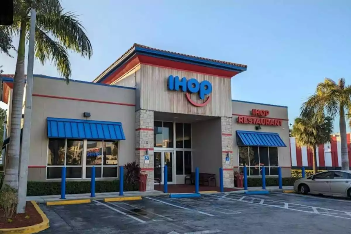 Front of a restaurant with the IHOP logo, surrounded by palm trees and parking lot. Front of a restaurant with the IHOP logo, surrounded by palm trees and parking lot.