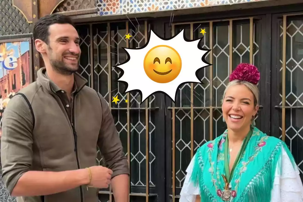 Un home i una dona somriuen mentre posen junts a l’aire lliure, amb un emoji de sol somrient entre ells i la dona porta un vestit tradicional amb mantó verd i una flor als cabells.