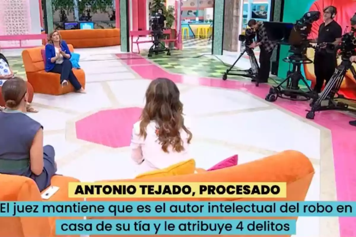 Un grup de persones és en un plató de televisió acolorit, amb càmeres i equip de gravació al voltant, mentre un text a la part inferior menciona un cas judicial. Un grup de persones és en un plató de televisió acolorit, amb càmeres i equip de gravació al voltant, mentre un text a la part inferior menciona un cas judicial.