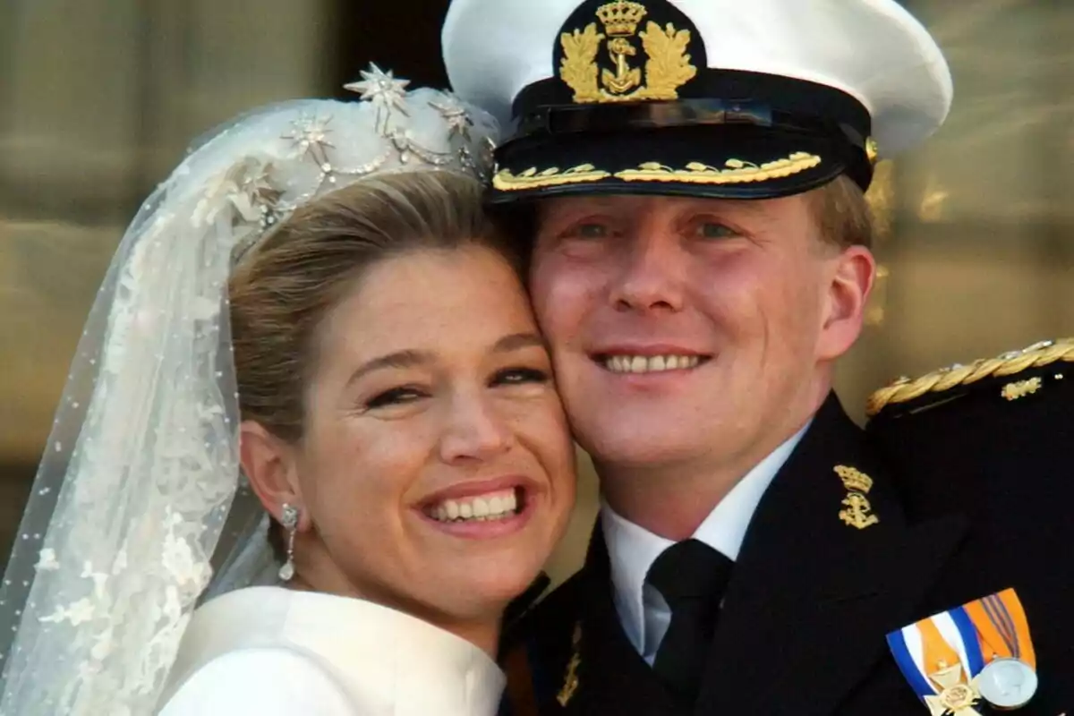 A smiling couple at their wedding, with the bride wearing a veil and the groom in a naval uniform. A smiling couple at their wedding, with the bride wearing a veil and the groom in a naval uniform.