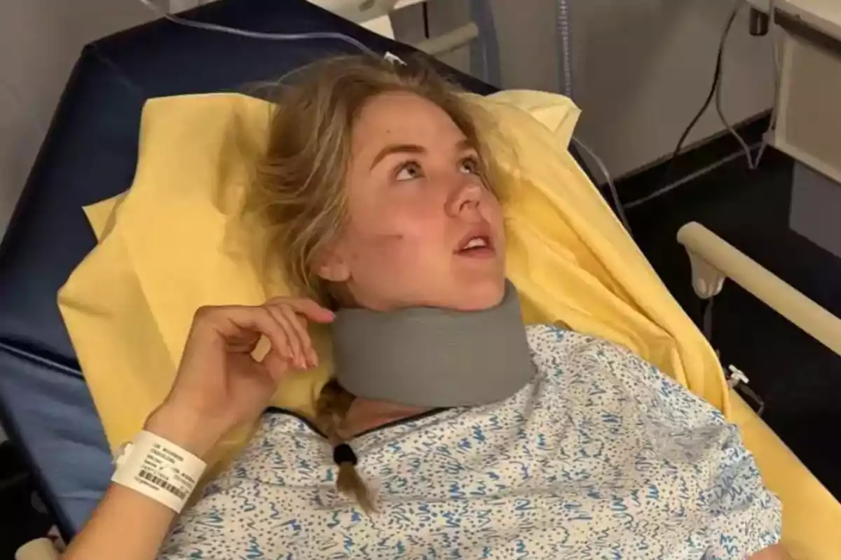 Dona jove estirada en una llitera d’hospital amb collarí cervical i bata mèdica mirant cap amunt Dona jove estirada en una llitera d’hospital amb collarí cervical i bata mèdica mirant cap amunt