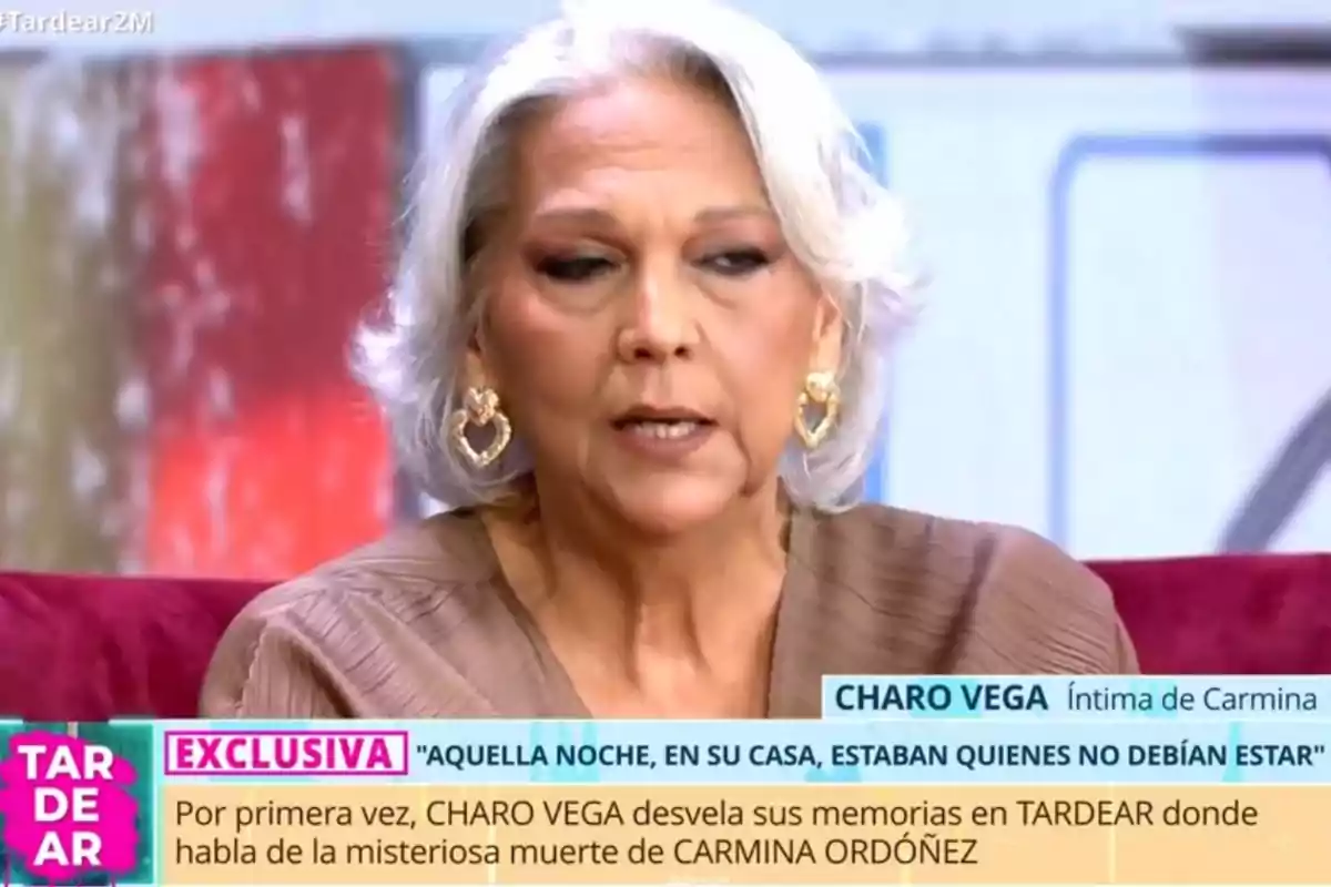 Una dona de cabell canós i curt està asseguda en un programa de televisió, porta arracades grans i daurades, i està parlant sobre un tema important mentre apareix un text a la part inferior de la pantalla. Una dona de cabell canós i curt està asseguda en un programa de televisió, porta arracades grans i daurades, i està parlant sobre un tema important mentre apareix un text a la part inferior de la pantalla.