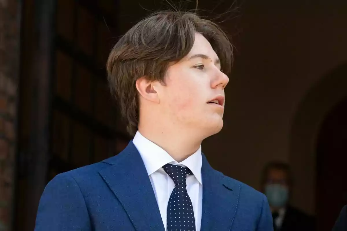 Un jove amb vestit blau i corbata de punts blancs mira cap a un costat. Un jove amb vestit blau i corbata de punts blancs mira cap a un costat.