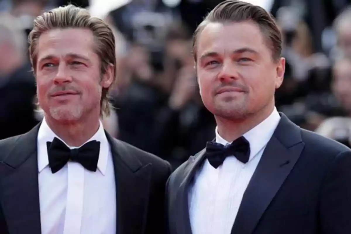 Two men in tuxedos pose together at a formal event. Two men in tuxedos pose together at a formal event.