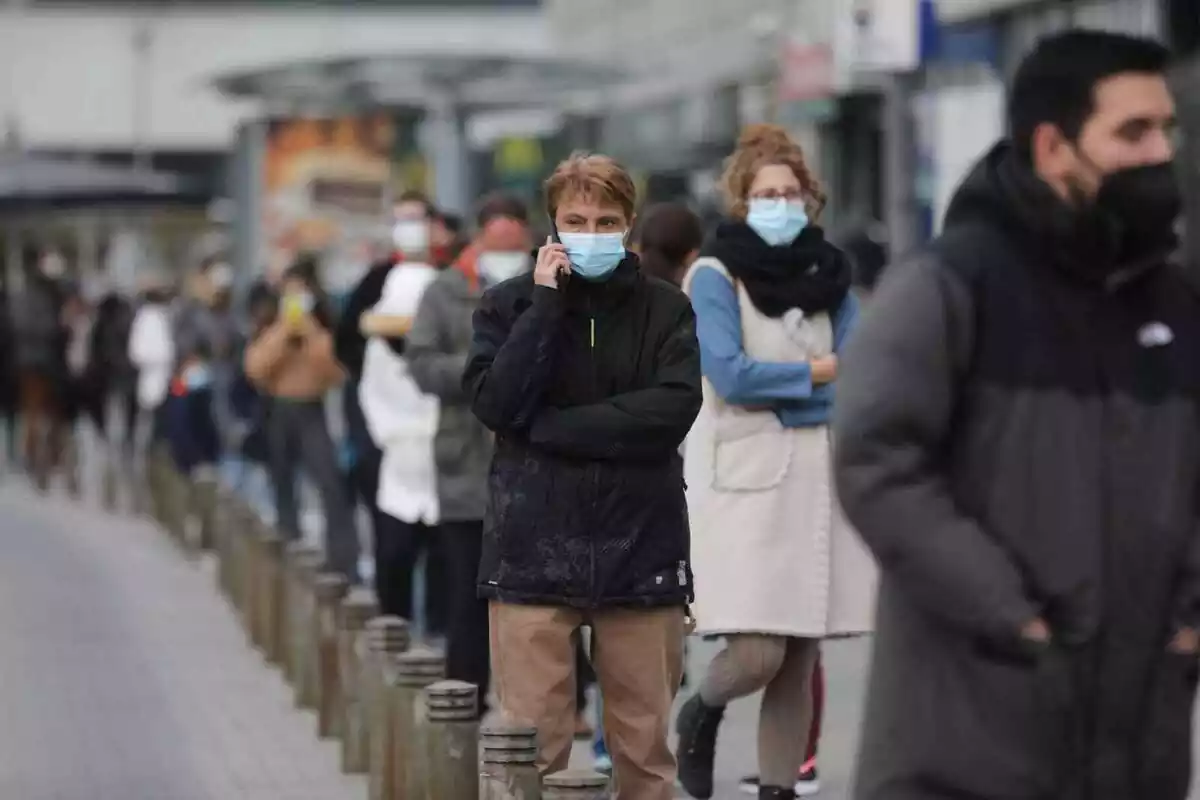 Un grup de persones amb màscares fent cua per ser vacunats durant la pandèmia