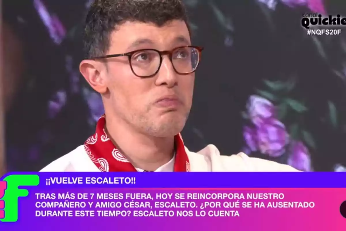 Un home amb ulleres i un mocador vermell apareix en un programa de televisió amb un text a la part inferior que anuncia el retorn d'un company anomenat Escaleto després de més de set mesos d'absència.