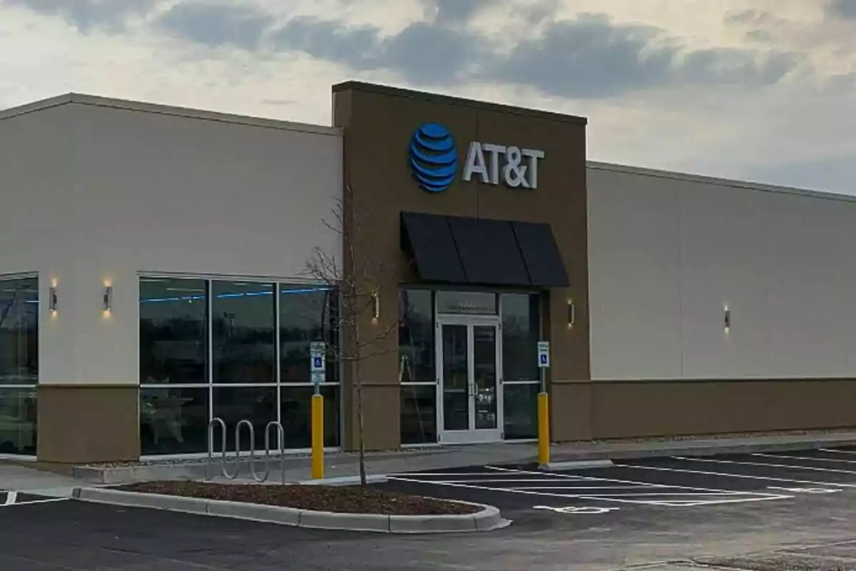 Fachada de una tienda de AT&T con un estacionamiento vacío al frente.