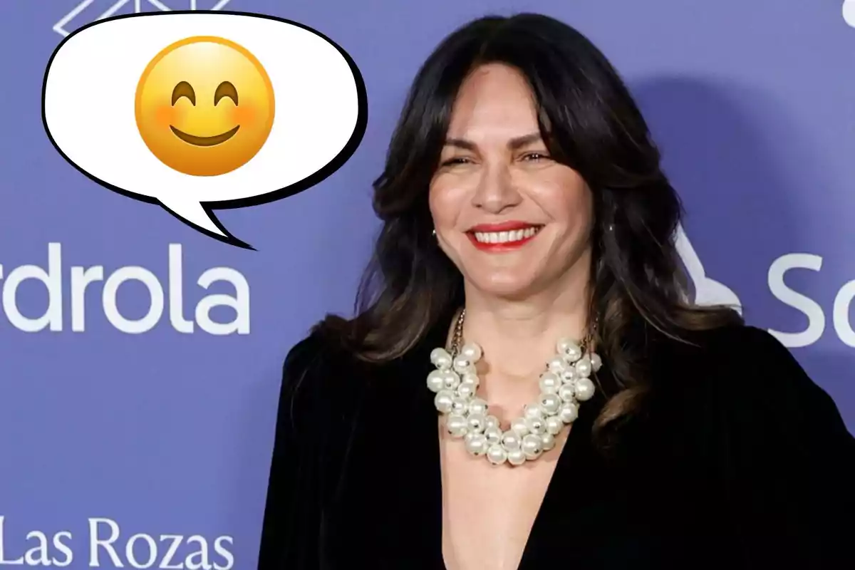 Una persona somrient amb un collaret de perles i un fons blau, acompanyada d'un globus de diàleg amb un emoji somrient.
