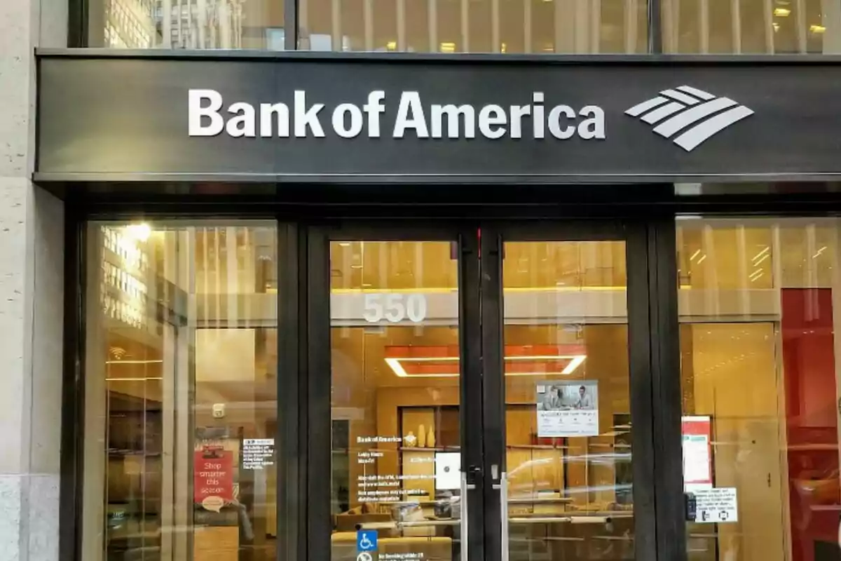 Entrada de una sucursal de Bank of America con puertas de vidrio y un letrero en la parte superior. Entrada de una sucursal de Bank of America con puertas de vidrio y un letrero en la parte superior.