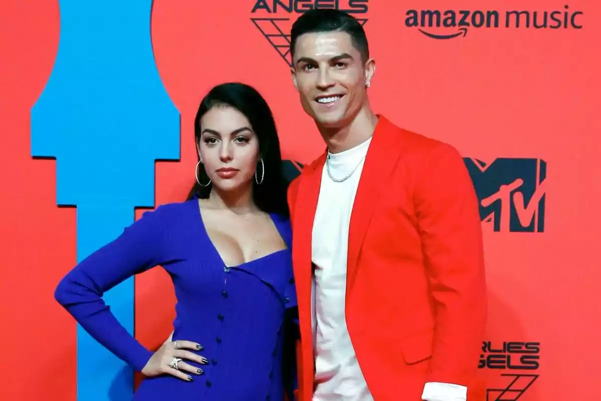 Pareja posando en una alfombra roja con fondo rojo y logotipos de MTV y Amazon Music Pareja posando en una alfombra roja con fondo rojo y logotipos de MTV y Amazon Music