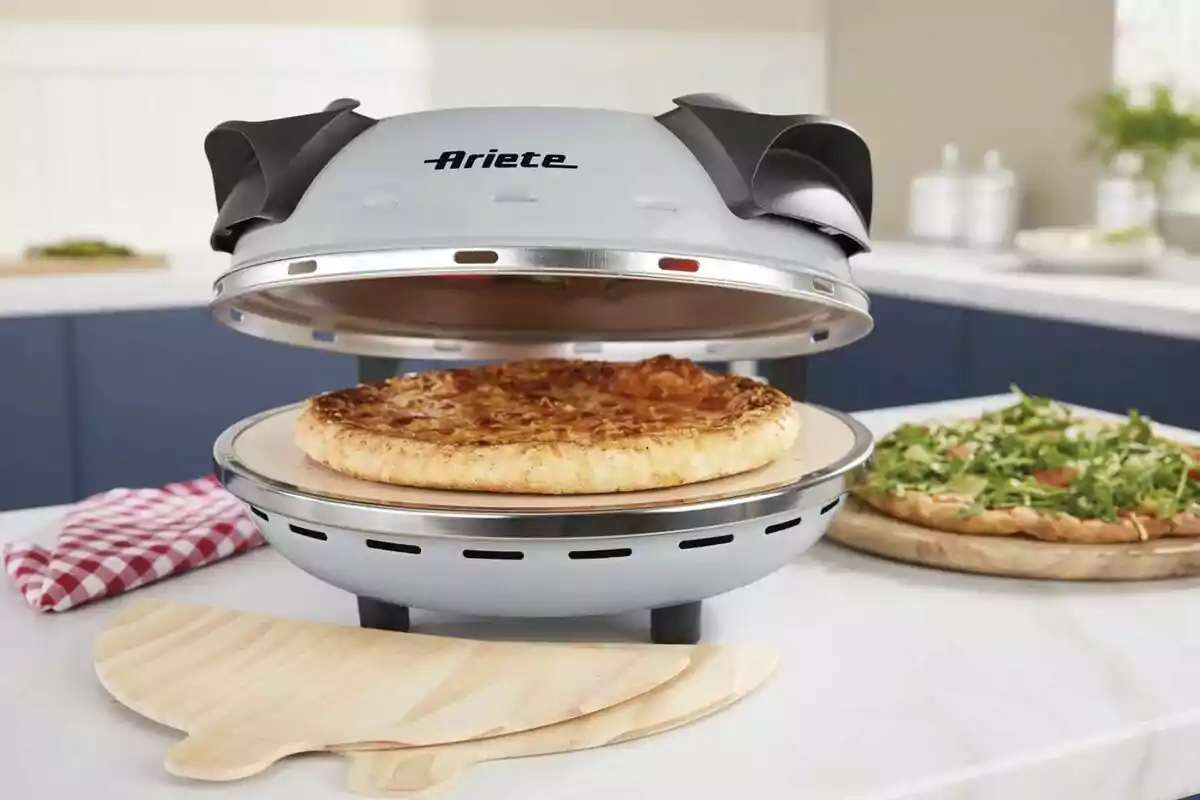 Forn elèctric per a pizza de Lidl amb una pizza cuinant-se al seu interior sobre un taulell de cuina. Forn elèctric per a pizza de Lidl amb una pizza cuinant-se al seu interior sobre un taulell de cuina.