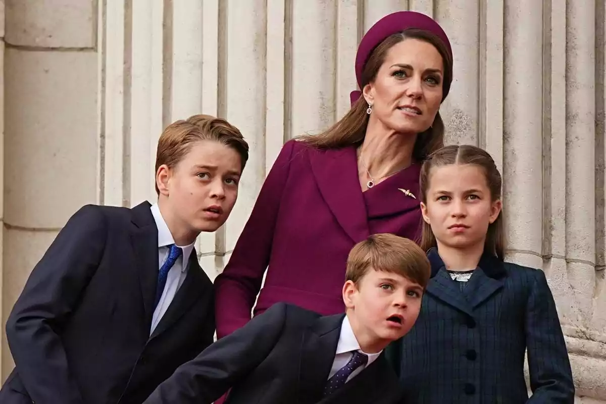 A woman and three children dressed formally look up with expressions of interest in front of a building with columns. A woman and three children dressed formally look up with expressions of interest in front of a building with columns.