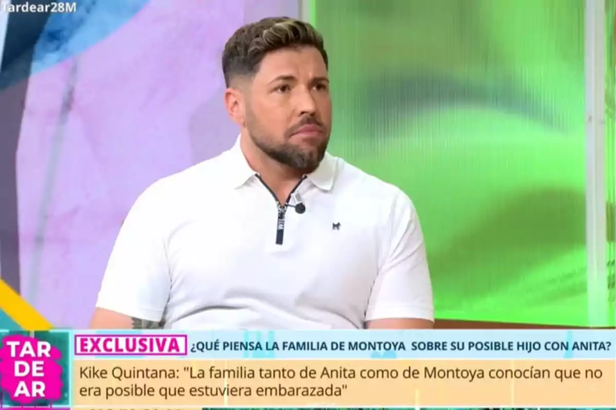 Home amb barba i samarreta blanca assegut en un plató de televisió amb gràfics de colors i un rètol informatiu a la part inferior de la pantalla. Home amb barba i samarreta blanca assegut en un plató de televisió amb gràfics de colors i un rètol informatiu a la part inferior de la pantalla.