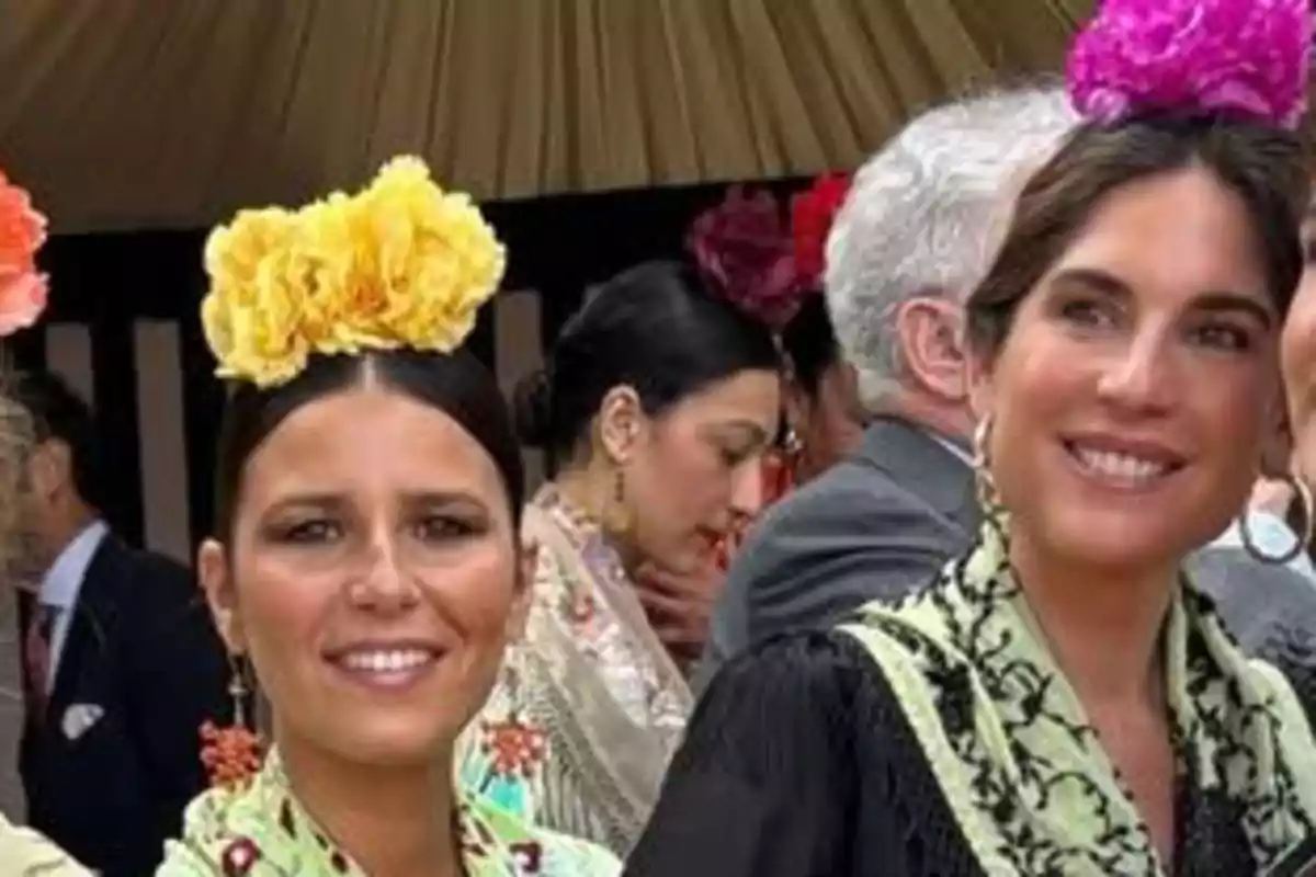 Persones vestides amb vestits tradicionals i flors al cabell en un esdeveniment a l'aire lliure. Persones vestides amb vestits tradicionals i flors al cabell en un esdeveniment a l'aire lliure.