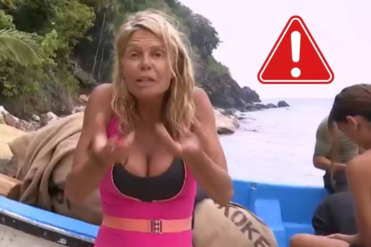 Dona rossa amb expressió preocupada a la platja al costat d’una barca blava i un símbol d’advertència vermell al fons