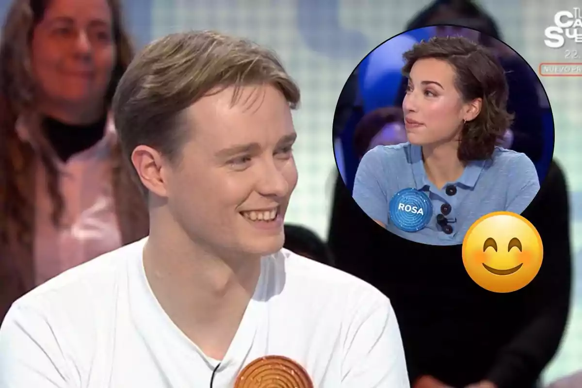 Un home somrient en un programa de televisió amb una imatge inserida d'una dona també al programa i un emoji somrient superposat.