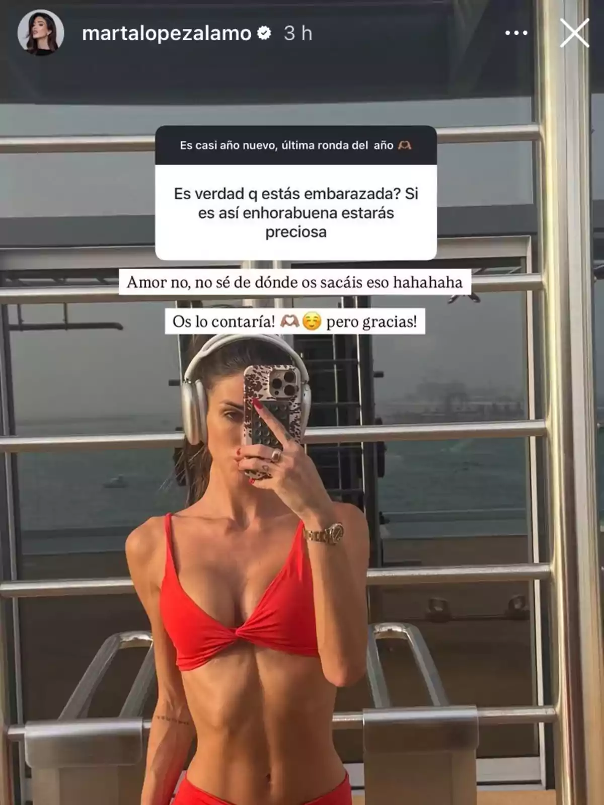 Marta López Álamo en biquini vermell es pren una selfie davant d'un mirall, amb auriculars i un telèfon a la mà. Hi ha text superposat a la imatge. Marta López Álamo en biquini vermell es pren una selfie davant d'un mirall, amb auriculars i un telèfon a la mà. Hi ha text superposat a la imatge.