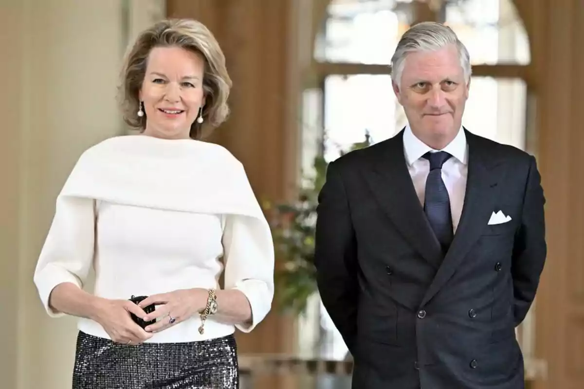 Two elegantly dressed people pose in an indoor setting. Two elegantly dressed people pose in an indoor setting.