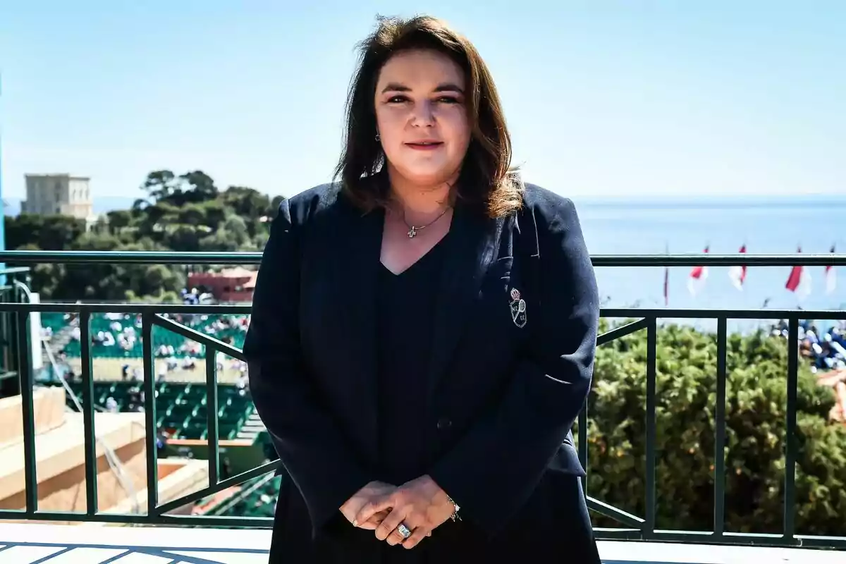 Una persona dreta en un balcó amb vista al mar i un paisatge verd al fons. Una persona dreta en un balcó amb vista al mar i un paisatge verd al fons.