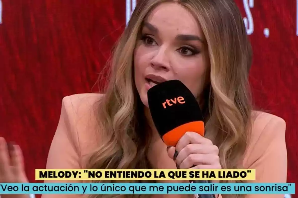 Dona de cabells llargs i rossos parlant en una entrevista mentre sosté un micròfon de rtve, amb un fons vermell i subtítols a la part inferior. Dona de cabells llargs i rossos parlant en una entrevista mentre sosté un micròfon de rtve, amb un fons vermell i subtítols a la part inferior.
