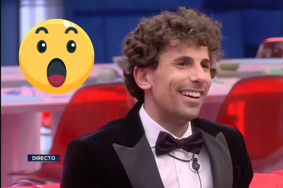 Un home somrient amb un emoji sorprès al costat en un entorn de programa de televisió.