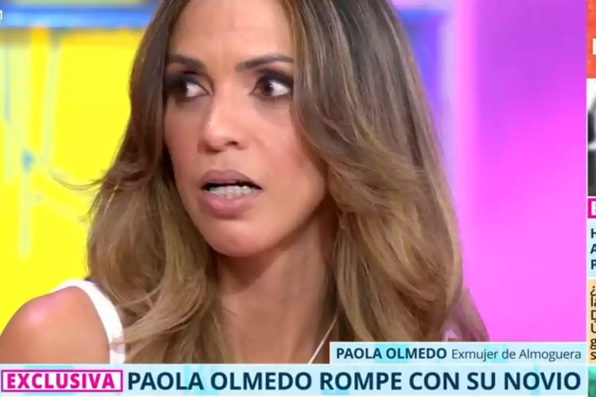 Dona de cabells llargs i ondulats amb expressió de sorpresa durant una entrevista en un programa de televisió, amb un rètol informatiu que anuncia una notícia exclusiva sobre la seva ruptura amorosa. Dona de cabells llargs i ondulats amb expressió de sorpresa durant una entrevista en un programa de televisió, amb un rètol informatiu que anuncia una notícia exclusiva sobre la seva ruptura amorosa.