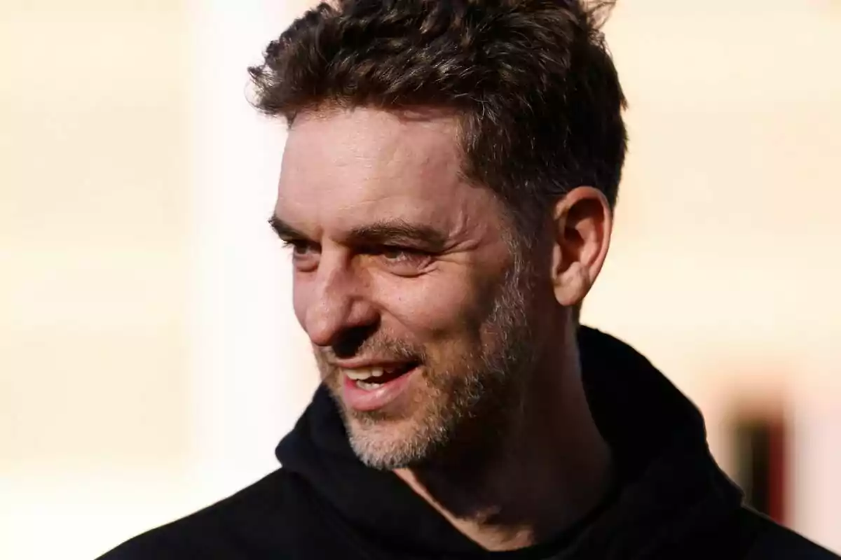 A man with a beard and short hair smiles while looking to the side, wearing a black sweatjersey. A man with a beard and short hair smiles while looking to the side, wearing a black sweatjersey.