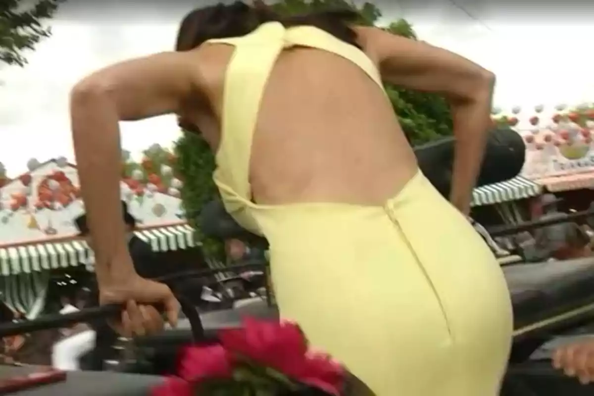 Una persona amb un vestit groc pujant a un carruatge en un ambient festiu amb decoracions i flors. Una persona amb un vestit groc pujant a un carruatge en un ambient festiu amb decoracions i flors.