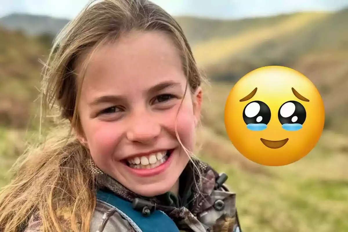 A smiling girl outdoors with an excited emoji next to her.