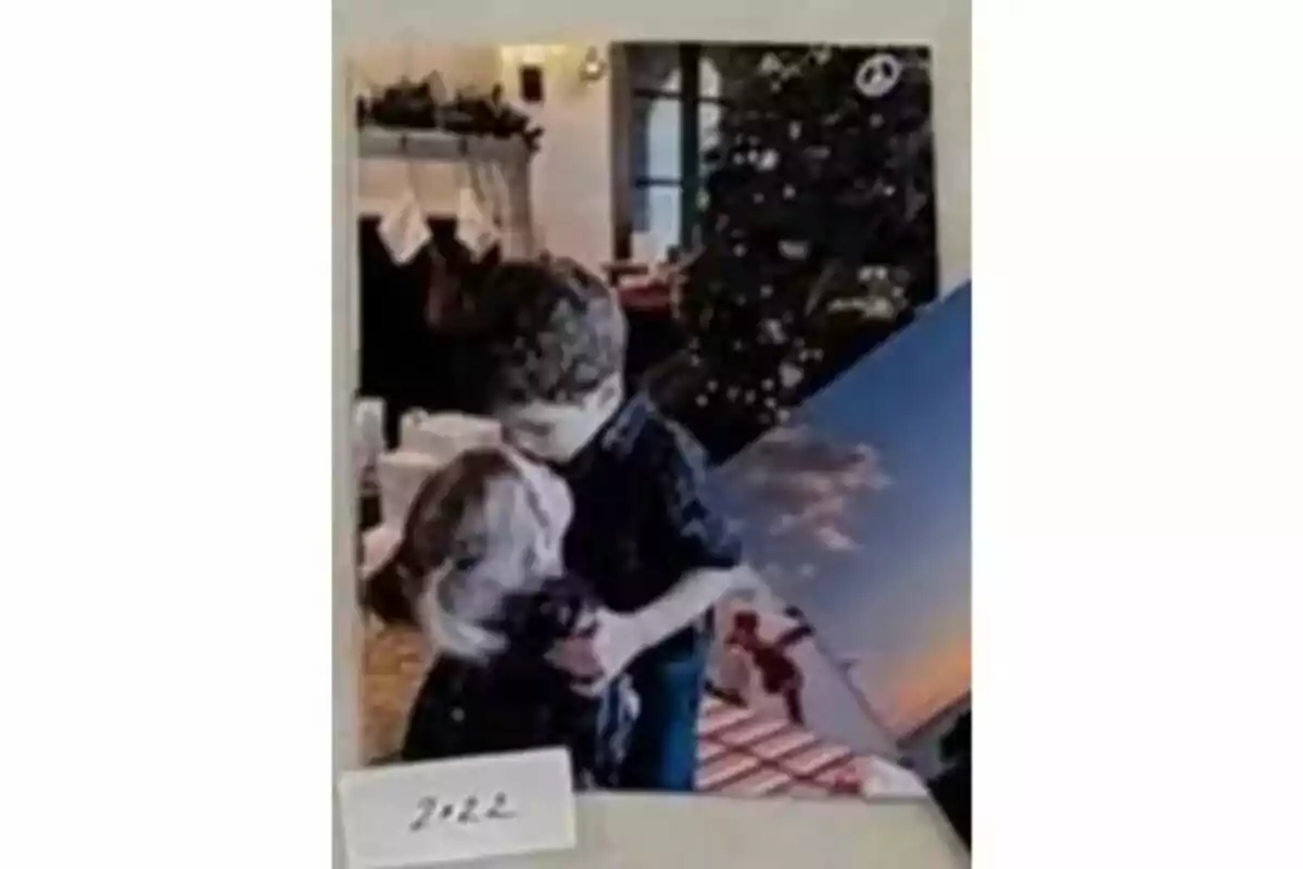Un niño abraza a un perro frente a un árbol de Navidad decorado, con una chimenea y medias colgadas al fondo. Un niño abraza a un perro frente a un árbol de Navidad decorado, con una chimenea y medias colgadas al fondo.