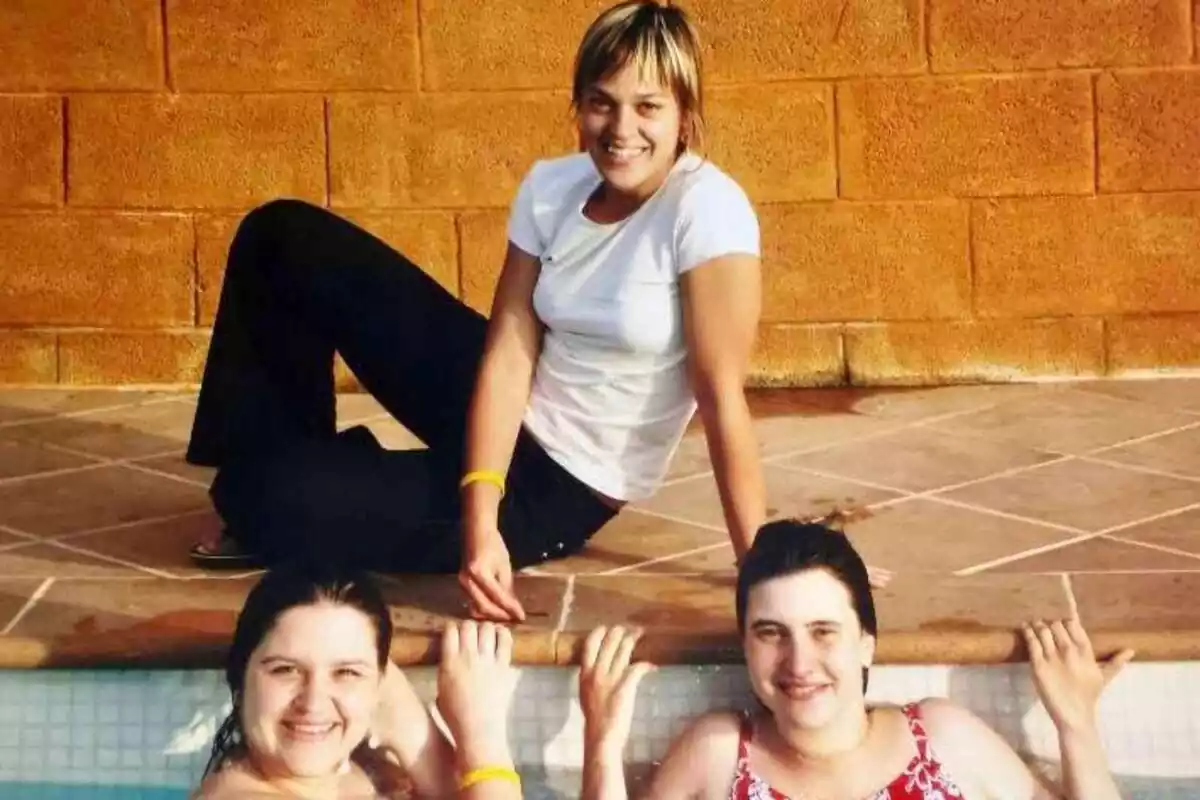 Imate de tres amigues assentades al costat d'una piscina