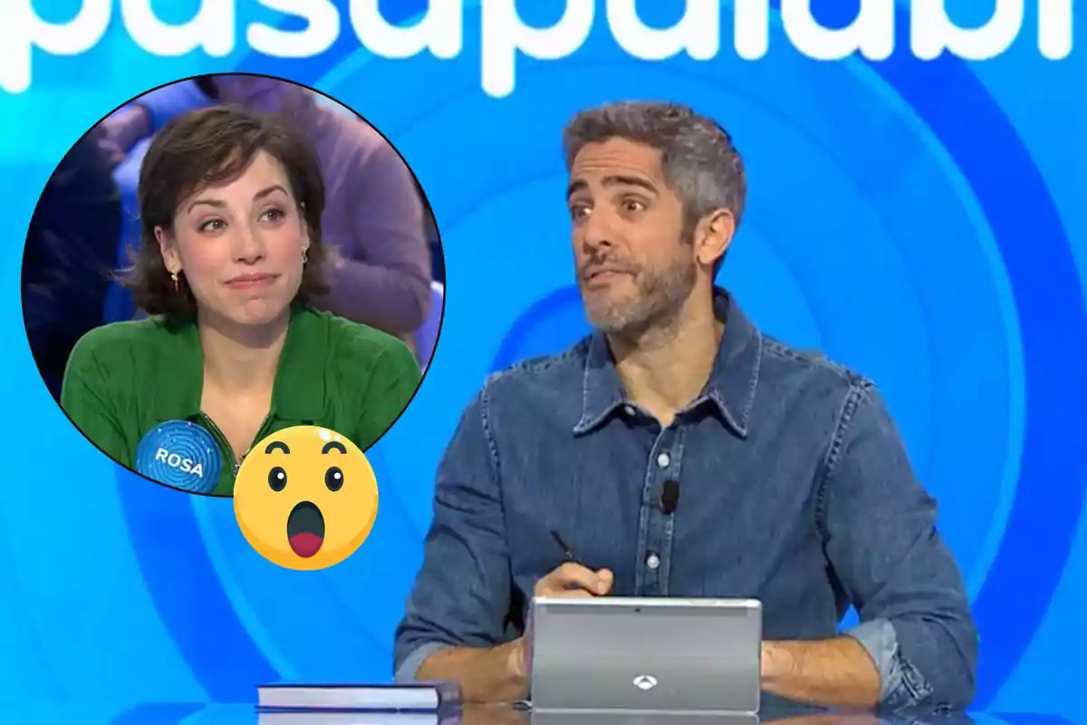 Un presentador de televisió està assegut davant d'una taula amb una tauleta, mentre una dona apareix en un cercle a la cantonada superior esquerra de la imatge, amb un emoji sorprès superposat.