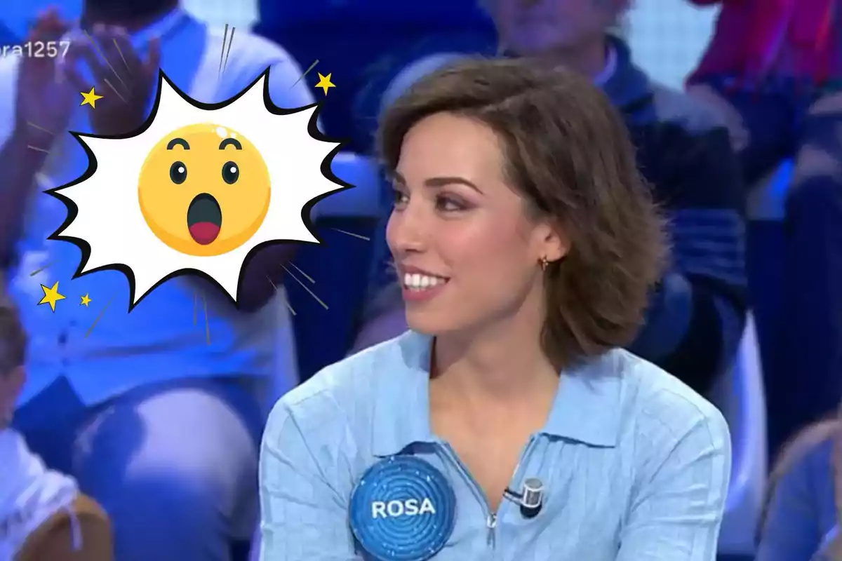 Una dona somrient amb una etiqueta que diu "ROSA" en un programa de televisió, amb un emoji sorprès superposat.