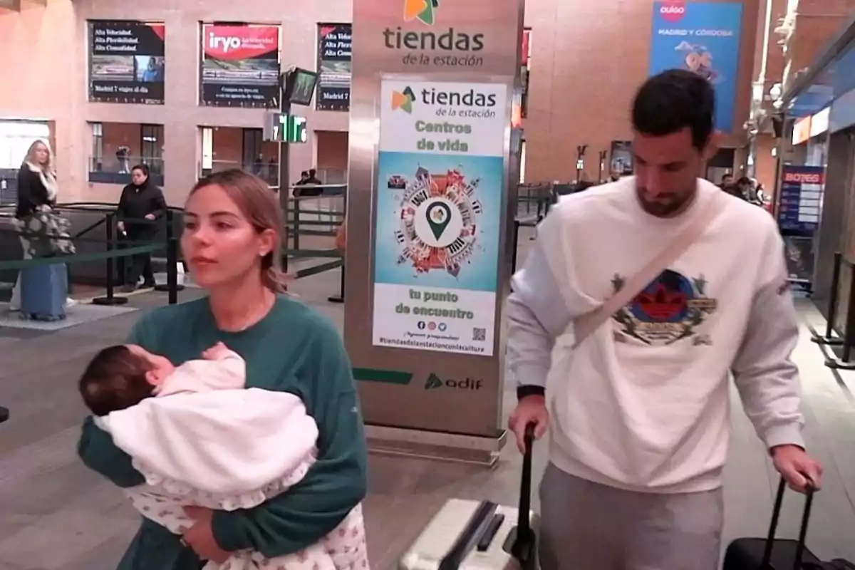 Alba Silva i Sergio Rico caminen en una estació de tren, l'Alba porta la Carla als braços i Sergio arrossega una maleta. Alba Silva i Sergio Rico caminen en una estació de tren, l'Alba porta la Carla als braços i Sergio arrossega una maleta.