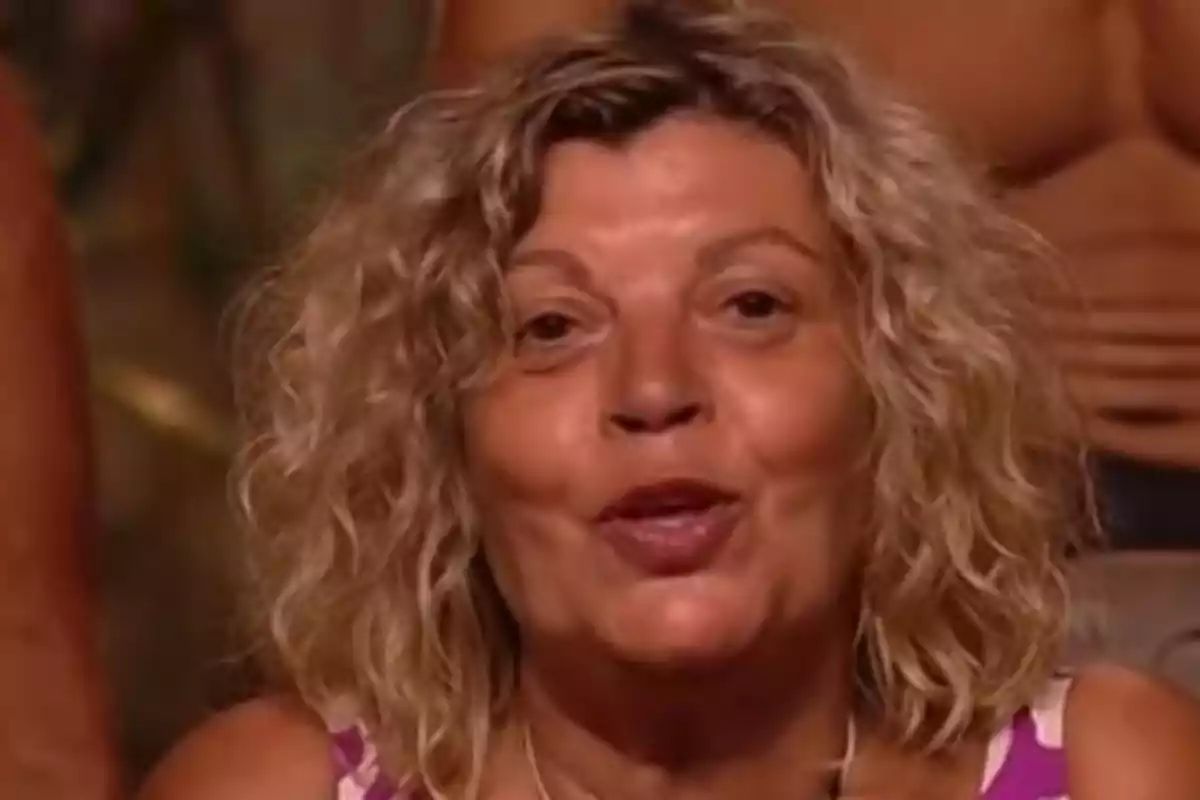 Dona de cabell ros arrissat i curt amb expressió somrient en un entorn interior Dona de cabell ros arrissat i curt amb expressió somrient en un entorn interior
