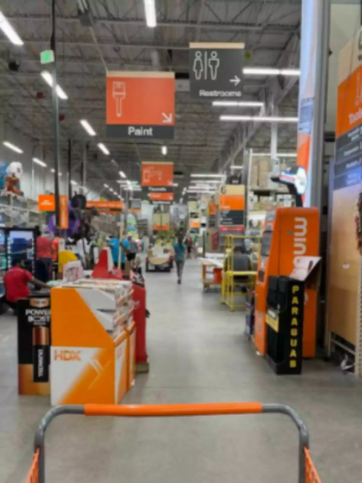 A The Home Depot store with aisles full of products and signs indicating the location of the paint section and the restrooms. A The Home Depot store with aisles full of products and signs indicating the location of the paint section and the restrooms.