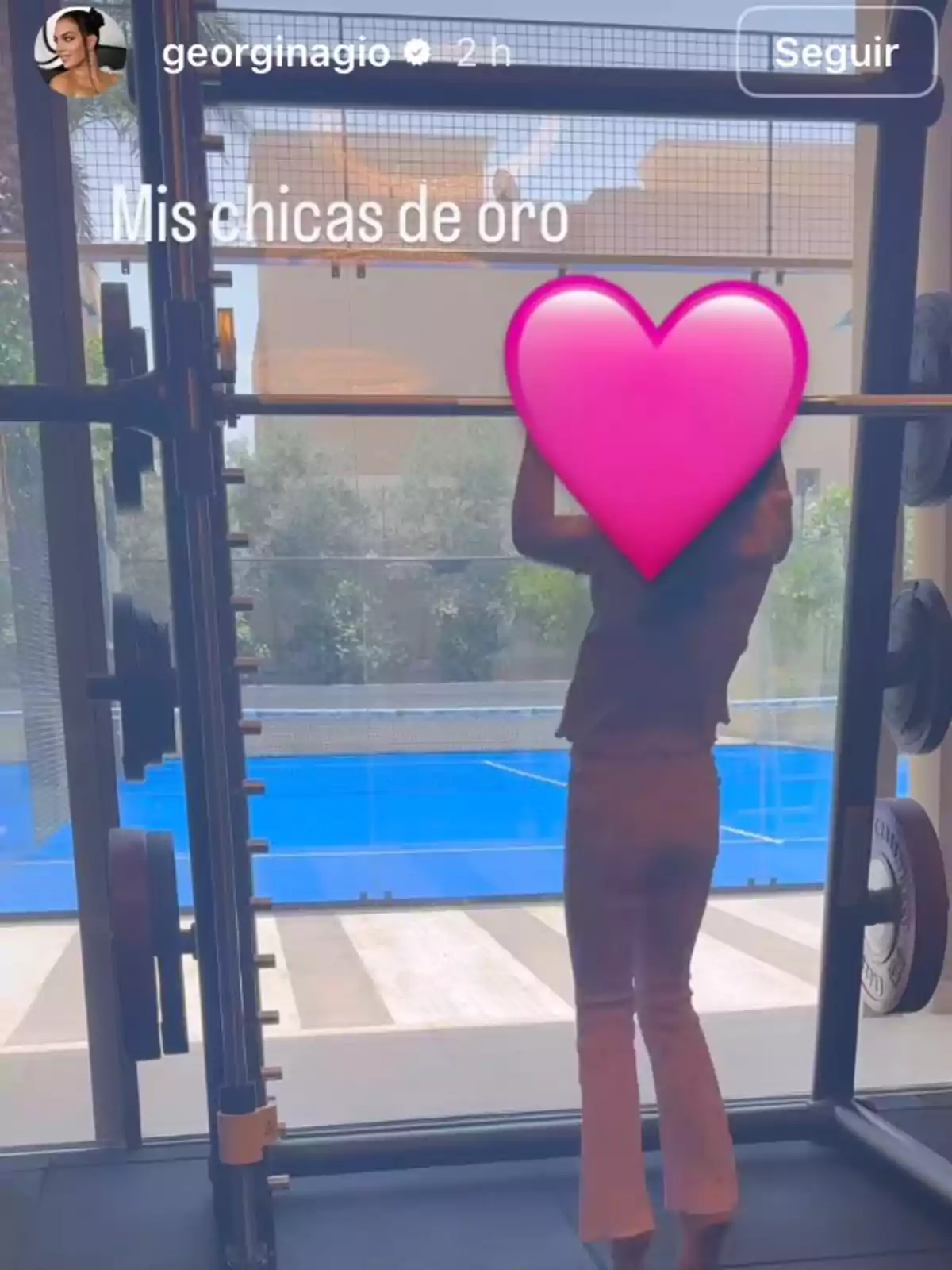 A person working out in a gym in front of a window overlooking a pool, with a pink heart covering their face and the text My Golden Girls A person working out in a gym in front of a window overlooking a pool, with a pink heart covering their face and the text My Golden Girls